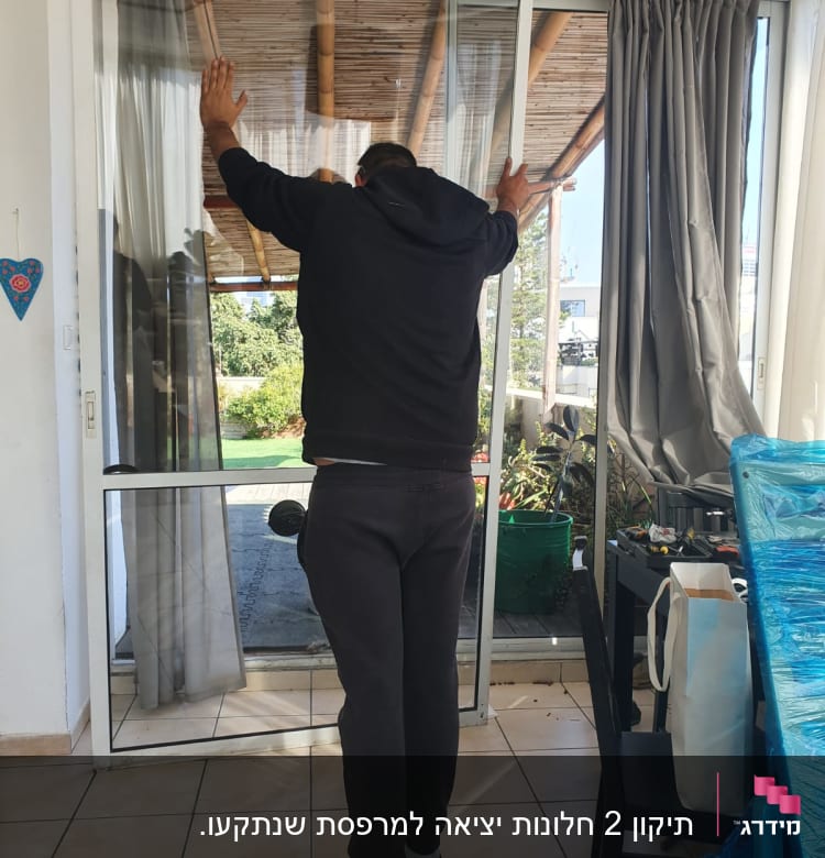 אדם מתקין דלת אלומיניום זכוכית בבית